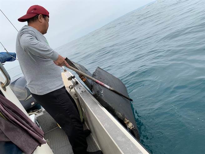 海洋环保舰队发现海龟被海废缠绕受困，立即以剪刀移除缠绕废弃物，协助海龟脱困。（新竹市政府提供／王惠慧新竹传真）