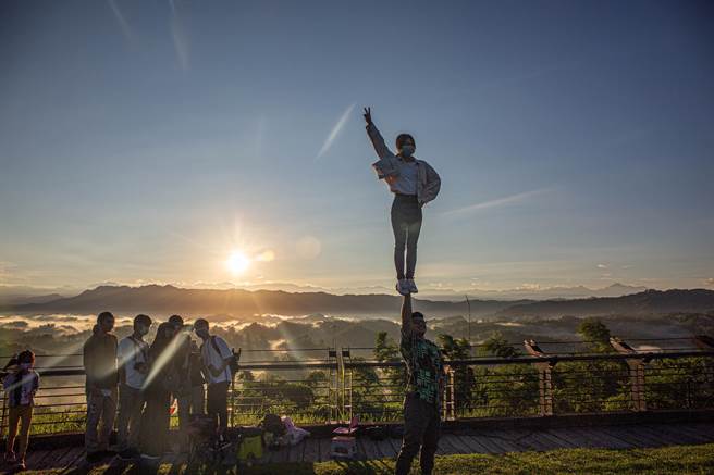 南臺科技大学啦啦队成员当场挑战单手将人举起高难度动作，留下独特的曙光云海美景合影留念。(西拉雅国家风景区管理处提供／曹婷婷台南传真)