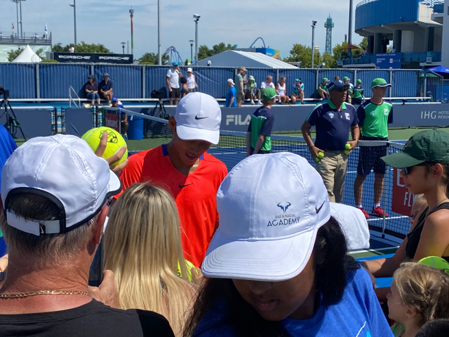 曾俊欣（后中红衣）在辛辛那提大师赛会外赛首场获胜后，被球迷包围索取签名。（曾育德提供）