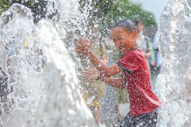 圖為大陸江蘇南京小朋友在街頭噴泉處戲水。（資料照／中新社）