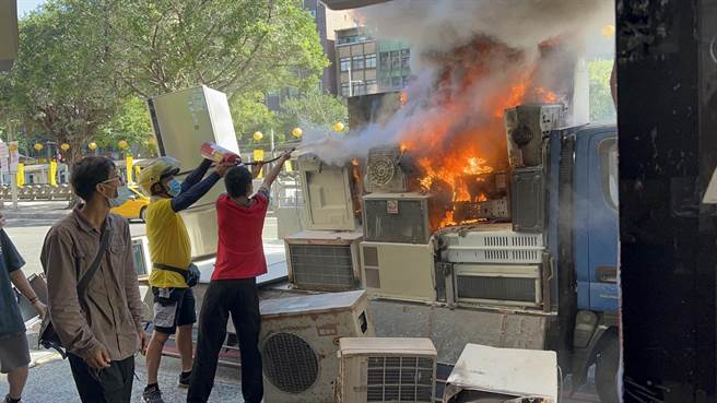 基隆市一台載送廢用電器小客車15日下午行經信一路時，不明原因起火燃燒。（陳彩玲攝）