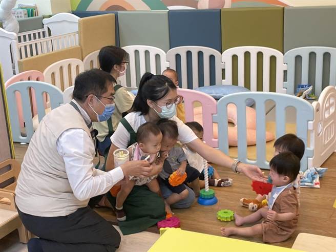 市长黄伟哲与托育家园内的幼儿玩在一起。（李俊淇摄）