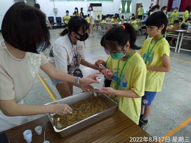 小朋友试吃刚煮好的黑糖。（台糖提供／李俊淇台南传真）