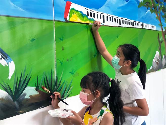 学童将图书馆的美丽火车窗景彩绘在5米的墙面上。（新北市立图书馆提供）