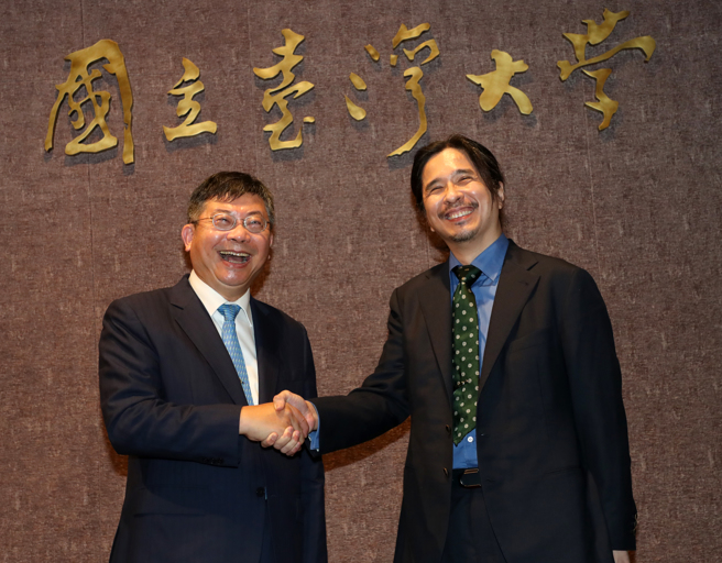 台湾大学17日举行校长遴选候选人治校理念说明会，参与校长遴选的台大医院云林分院前院长黄瑞仁（左）与台大电机系教授叶丙成（右）相互握手致意。（刘宗龙摄）