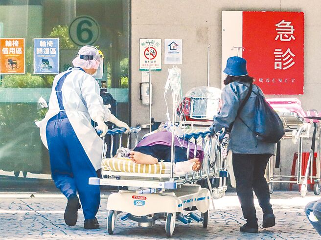新冠疫情應變，讓醫人員護上緊發條。圖為醫護及家屬將一名病患拉至醫院的防疫急門診。（本報資料照片）