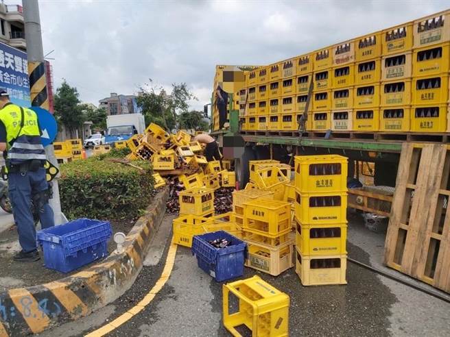 冈山一辆满载米酒的曳引车疑似未固定好车上物品，导致米酒散落一地，警方到场处理。（翻摄照片／林瑞益高雄传真）