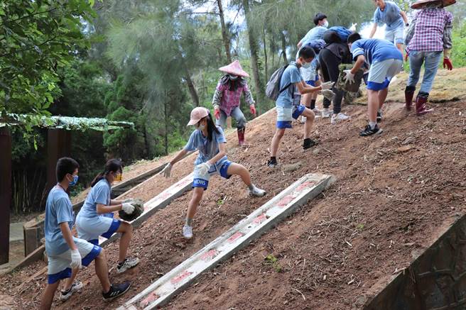 明道中學學生透過傳遞方式，在退役的彈藥庫鋪植草皮。（金門縣林務所提供）