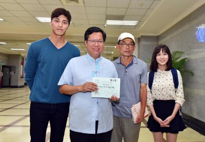 韩剧「非常律师禹英禑」在台湾掀热潮。桃园市长郑文灿（左2）表示，饰演禹英禑的韩星朴恩斌（右），曾为拍戏到桃园市政府取景，并秀出当时两人合照。左为同行的韩国演员李太奂。
（图/ 中央社）
