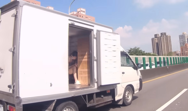 重机骑士发现高架上有辆货车舱门未关，一靠近查看时，竟发现有名短裙正妹坐在里面。（翻摄自YouTube频道「WoWtchout - 地图型行车影像分享平台」）