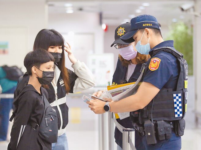 在桃園機場第二航廈出境大廳內，航警向前往柬埔寨的旅客關懷詢問，避免有人受害。（范揚光攝）