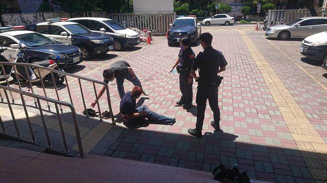 醉汉受不了炎热地板，逐渐醒转，却仗酒胆，出口喝斥帮忙联络家人的警员。（程炳璋摄）