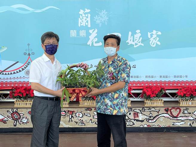 台電副總經理簡福添（左）將復育蘭花交給蘭嶼鄉長夏曼·迦拉牧（右），象徵蘭花回到娘家蘭嶼。（莊哲權攝）