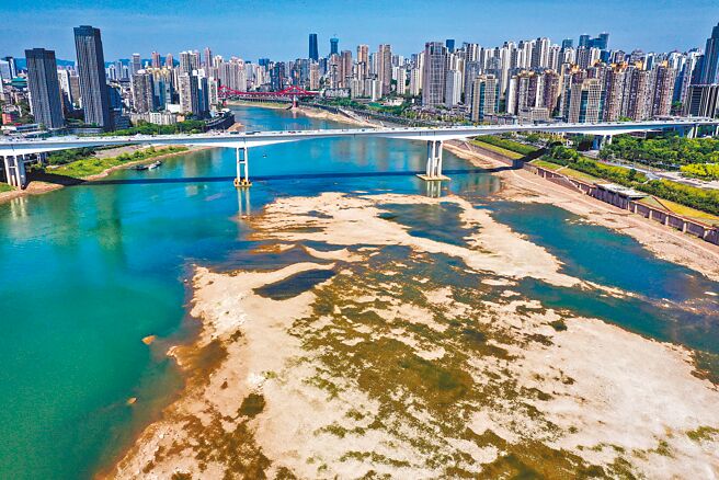 大陸南方「汛期反枯」，圖為19日流經重慶主城區的嘉陵江水位降低，一些灘塗地裸露出來。「汛期反枯」的罕見現象是上游來水減少、連晴高溫少雨天氣所致。（新華社）