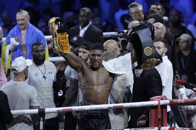 乔雪赛后把两条腰带拿起来扔到场下。（美联社）