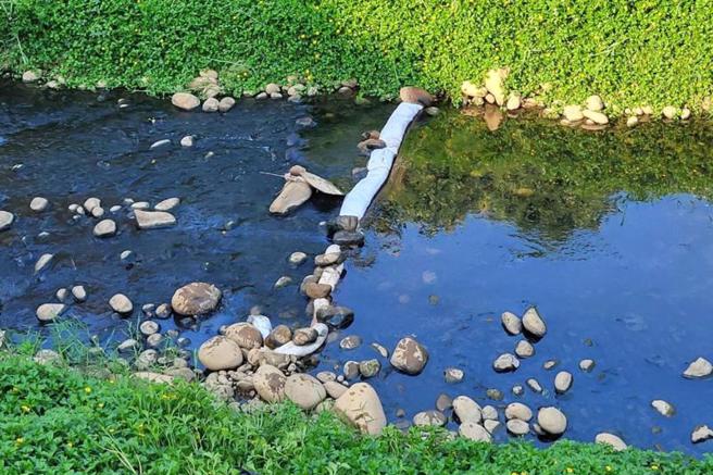 桃园市观音区观音溪出现油污污染，环保局获报派员前往稽查，发现1家纤维工厂为油污源头，最高可裁罚新台币300万元，并限期26日前改善完成。（图/ 中央社）