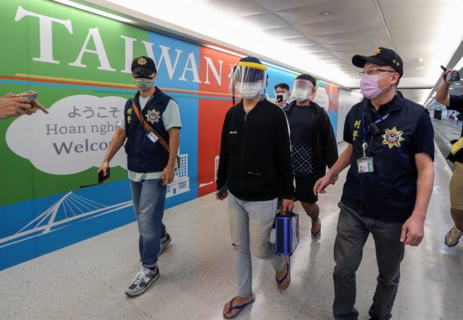 國民黨立委3名立委日前自柬埔寨救援1名青年返台，但透露還有1名青年滯留未歸。鄭正鈐21日受訪時表示，原本滯留未歸的18歲鄭姓男子於21日下午搭機回台，機上除了鄭姓青年（戴鴨舌帽者）外，還有另外一名張姓關係人，也搭乘同航班一同抵台。張姓關係人（中後）身穿印有「LV」花紋T恤，手提印有「我愛柬埔寨」英文字樣的提袋，顯得格外諷刺。（陳麒全攝）