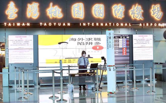 在桃园机场第二航厦出境大厅内，大型电视墙播放宣导短片呼吁出国旅客小心谨慎。（范扬光摄）
