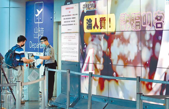 近期国人赴柬埔寨工作屡遭诈骗，甚至被人蛇集团控制贩卖而引发各界关注。在桃园机场第二航厦出境大厅内，大型电视墙播放宣导短片呼吁出国旅客小心谨慎。（范扬光摄）