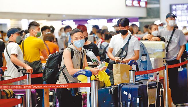 近期國人赴柬埔寨工作屢遭詐騙引發各界關注，政府呼籲前往東南亞國家的旅客務必小心謹慎。在桃園機場第一航廈出境大廳內，前往越南的旅客排隊辦理報到手續。圖片中的人物並非新聞當事人。（范揚光攝）