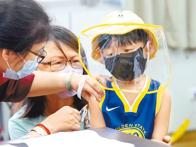 在北市妇幼医院的新冠肺炎疫苗接种站一位小朋友在家人的陪伴下，忍住疼痛接受疫苗接种。（郑任南摄）