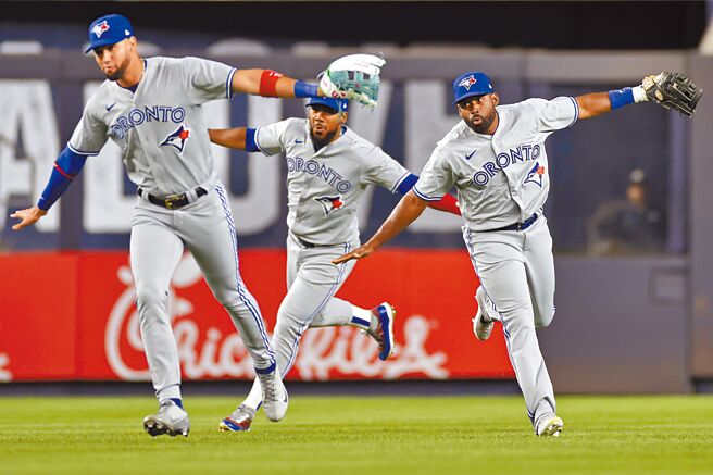 起飞了！蓝鸟昨天完封击败洋基后，3名外野手做出飞翔动作庆祝胜利。（美联社）
