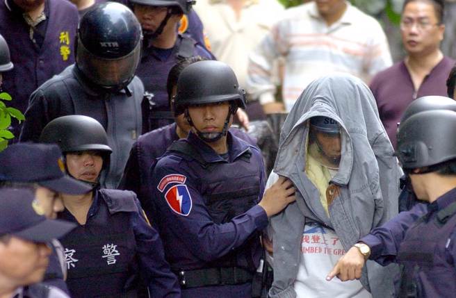 警方逮捕涉嫌枪杀横科所员警的兄弟檔嫌犯，哥哥王柏忠（右二头套衣服者）与弟弟王柏英（左二戴安全帽者）在警力戒护下押解上车。（中时资料照 季志翔摄）