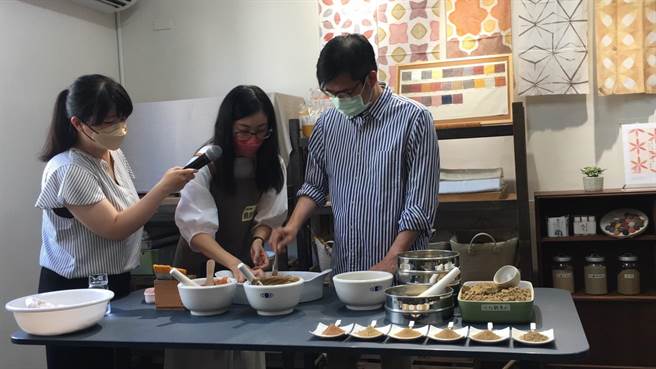 陈其迈由翁綉惠指导下，体验泥染手作。（崔正纲摄）