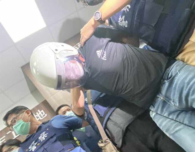 林信吾被押解至台南市警三分局，全程低头不语。（曹婷婷摄）