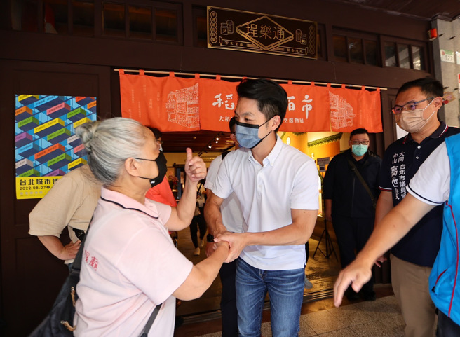 国民党台北市长参选人蒋万安（中）23日走访台北市大同区迪化街埕乐通参观稻埕佰市展，途中民眾频频对蒋万安竖起大拇指。（陈信翰摄）
