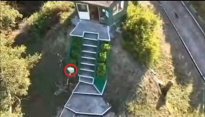 大陆无人机飞越我烈屿上空，我方两名驻军以石块（左下方红圈处）丢掷。（取自微博）