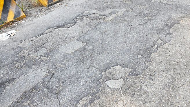 基隆市安乐区壮观台北社区联外道路为私人土地，年久失修路面破损不堪，坑洞时常造成机车摔车。（陈彩玲摄）