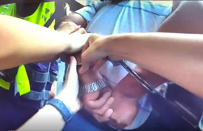 女警盘查时老翁不但大骂三字经，还挥拳攻击，警方见状先喷辣椒水，将他压制上铐带回警局。(翻摄自影片)