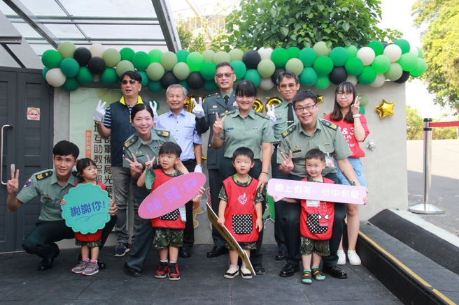 家长带着身着「迷彩套装」的孩子一同体验幸福植栽活动，不仅增进亲子互动，也让学童家长进一步认识教保中心环境，现场气氛热闹温馨。(军备局提供)