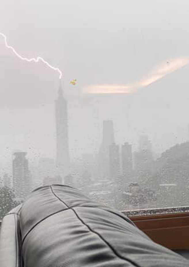 網友拍下雷擊命中101頂端的瞬間，嚇得直說：「雷雨真大！」。（圖／信義區兩三事）