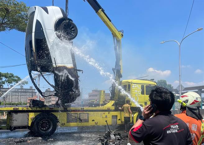 桃园市消防局长谢吕泉坦言电动车因底盘是锂电池组，抢救困难且灭一台要10吨水，未来研拟出动拖吊车，90度吊起方便射水灭火。（蔡依珍摄）