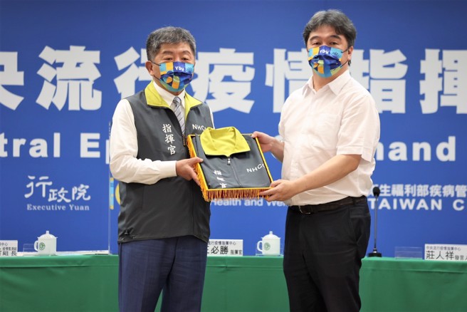 疫情指挥中心日前公布确诊数字前，举行指挥官交接仪式。（图／指挥中心提供）
