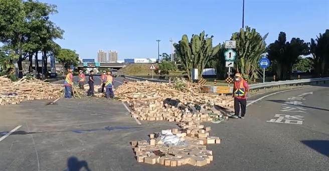 曳引车下永康交流道失控自撞分隔岛，木料散落一地。（警方提供／曹婷婷台南传真）