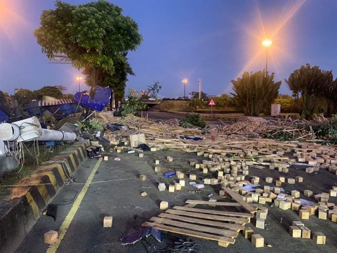 曳引车下永康交流道失控自撞分隔岛，木料散落一地。（警方提供／曹婷婷台南传真）