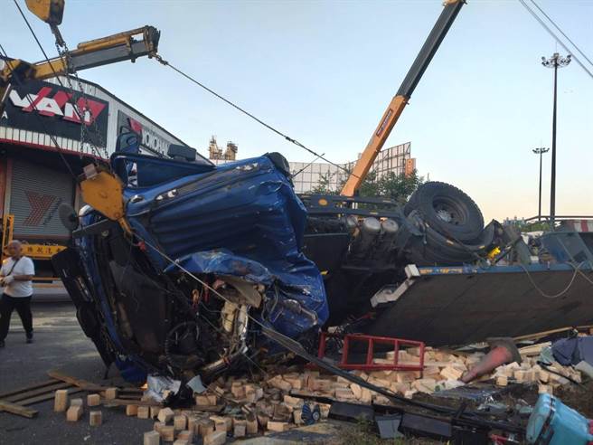 曳引车下永康交流道失控自撞分隔岛，木料散落一地。（警方提供／曹婷婷台南传真）