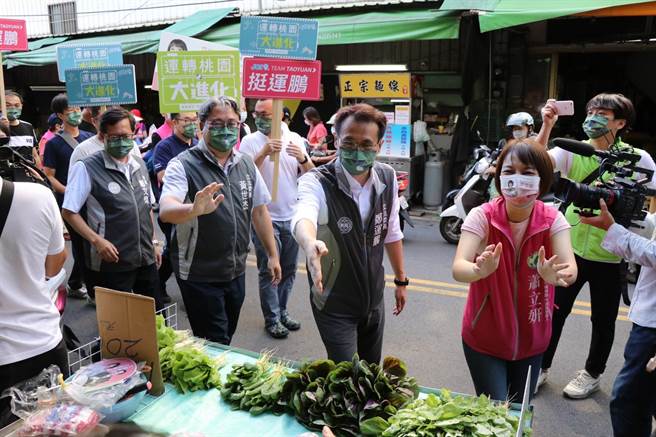 民进党桃园市长参选人郑运鹏向摊商与民眾一一请托。（蔡明亘摄）