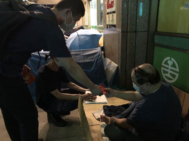 仕招基金會志工深夜到台北車站送暖，致贈街友慰問金。（張芷瑜攝）