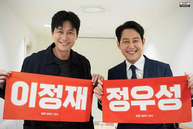 李政宰（右）和郑雨盛近日为《猎首密令》积极跑宣传，互拿写着对方名字的手幅合照。（摘自IG）