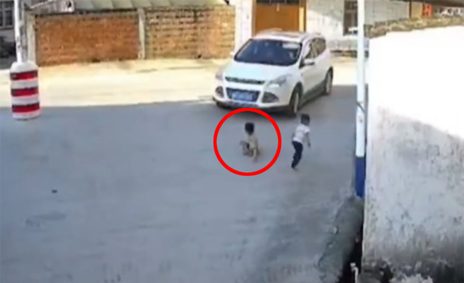 男童蹲在路邊玩耍，不料卻被白色休旅車輾過並捲進車底。（圖片翻攝自微博／@平安北京）