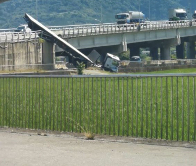 台9线拖板车衝撞撞护栏，车身卡富里大桥，车上货物沿路掉满地。（图／民眾提供）