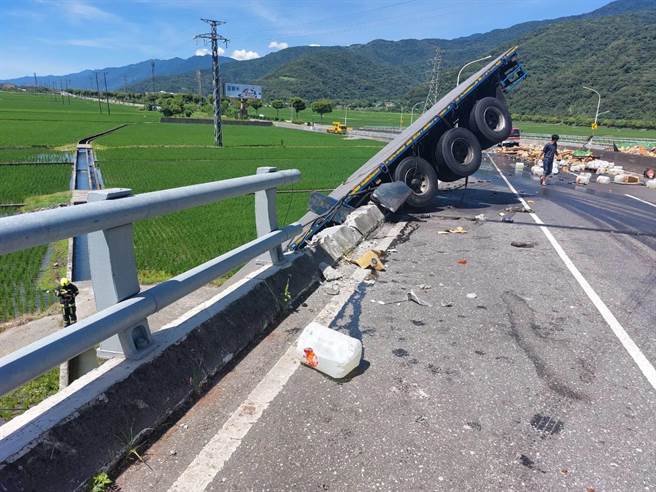 拖板車翻落橋下，現場怵目驚心。（警方提供）