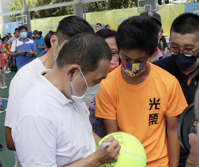 侯友宜替小选手在大网球上签名留念。（新北市工务局提供）