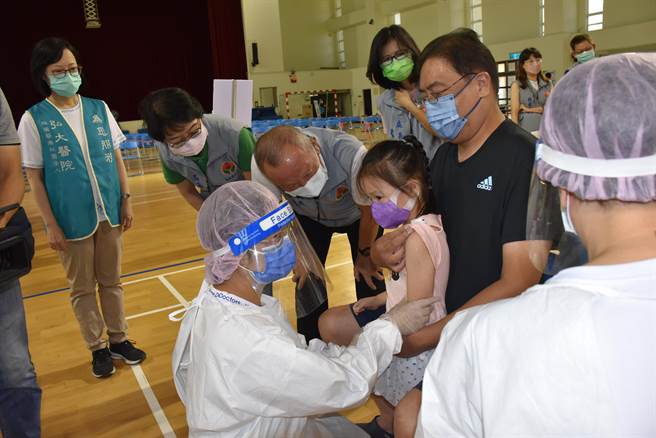 苗栗县长徐耀昌弯腰鼓励小朋友勇敢打疫苗。（谢明俊摄）