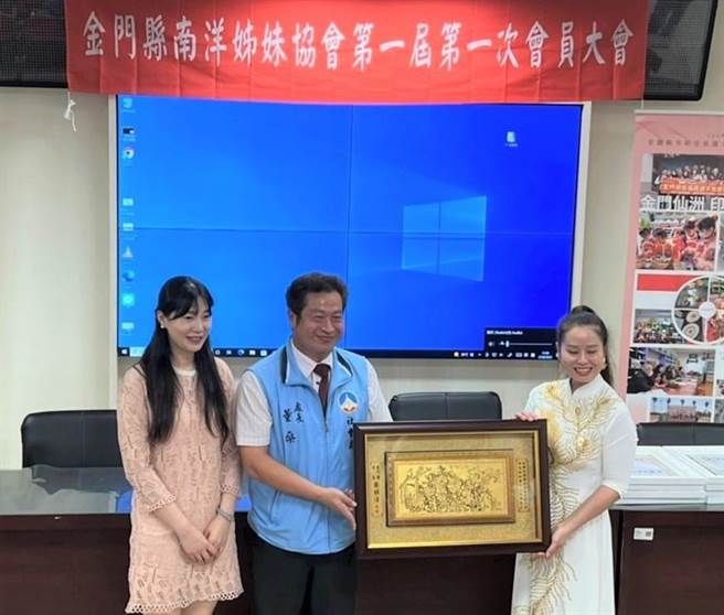 县府社会处长董燊颁发首任理事长郑氏侨萤当选证书，杨镇浯县长夫人张娅玲（左）到场祝贺。（县府提供）。