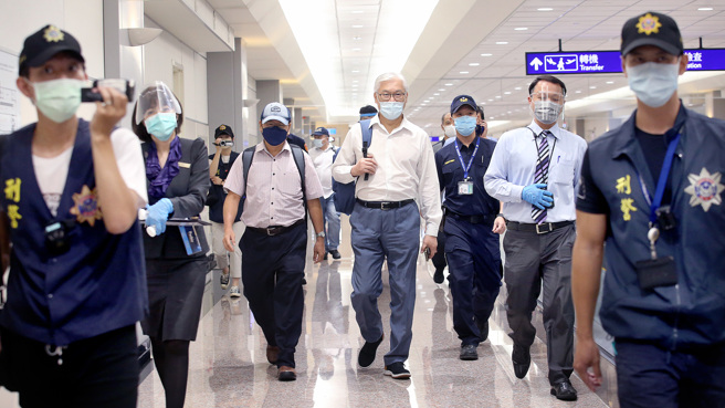 国民党副主席夏立言（中）27日返台，他下机后面对媒体并未发表谈话，并在眾人陪同下走商务中心通关入境。（范扬光摄）